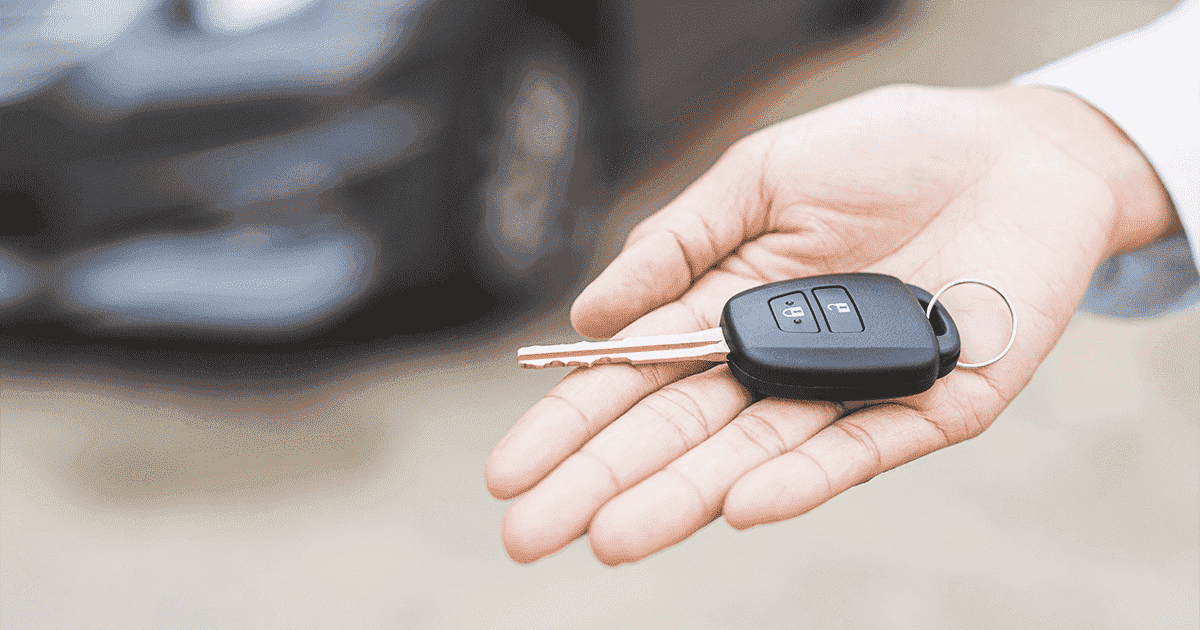 Imagem de uma pessoa segurando a chave do carro na palma da mão.